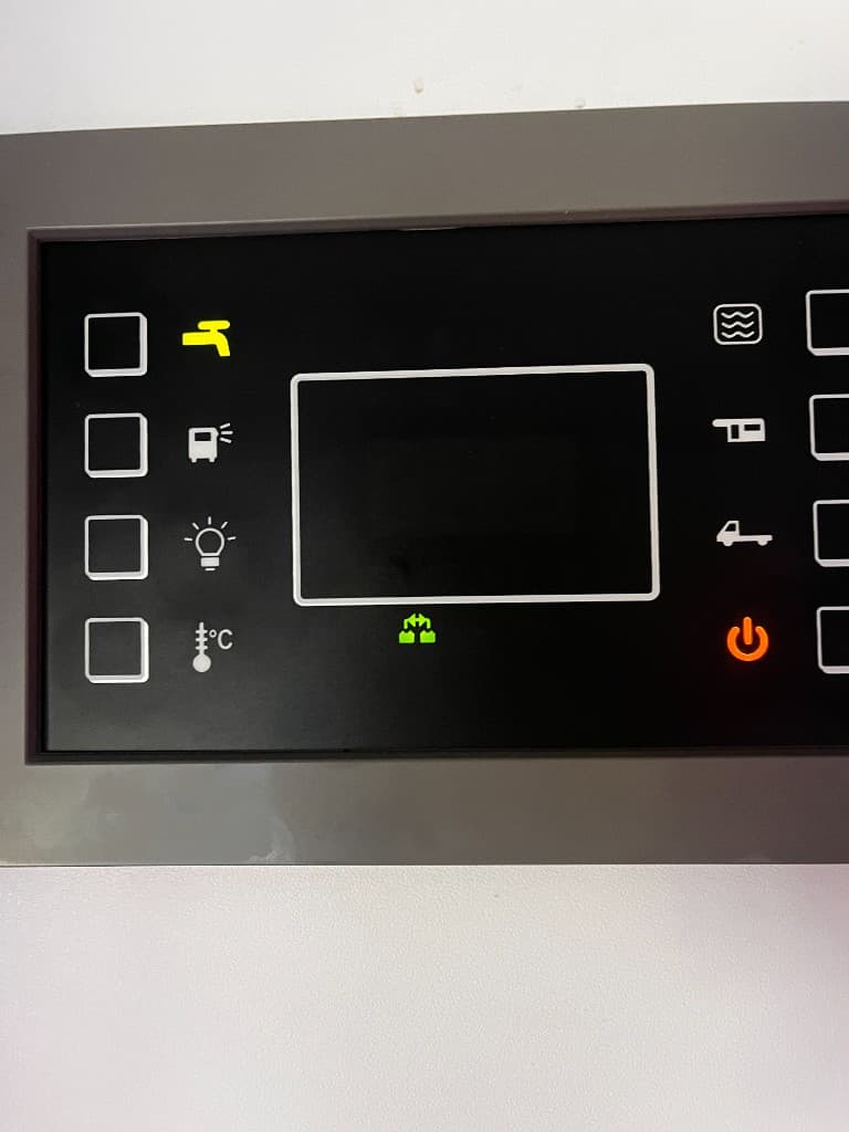 Zdjęcie panelu sterowania użyte do wyjaśnienia ikon wody i akumulatorów. Dla właściciela to cenna wskazówka, które oznaczenia są dla najemców nieczytelne.